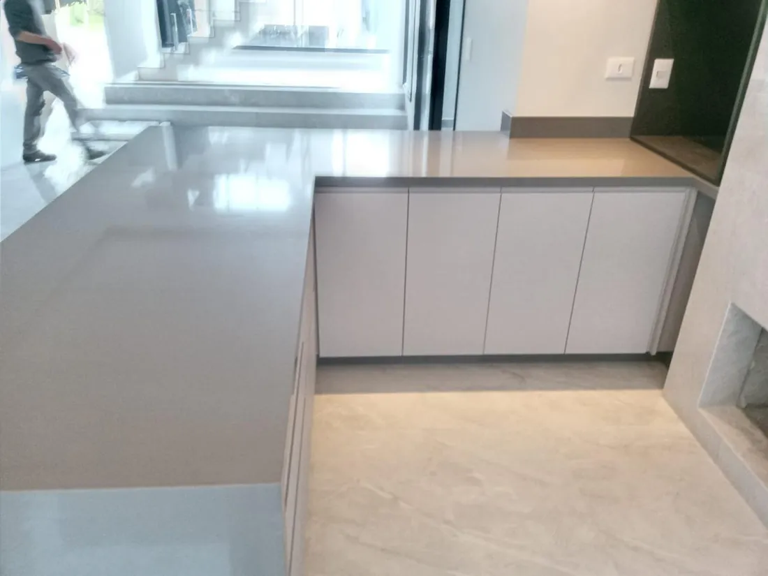 Bancada cinza com marcenaria clara em cozinha integrada