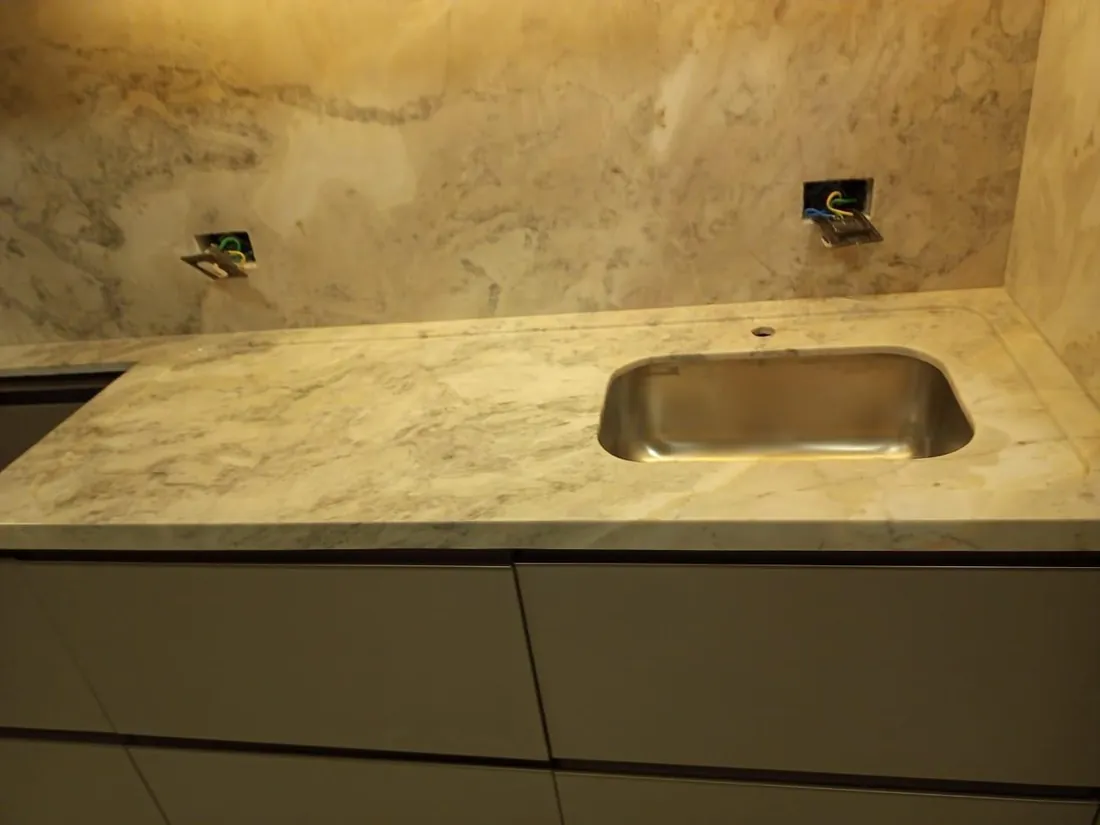 Detalhe de cuba esculpida em pedra com frontão iluminado
